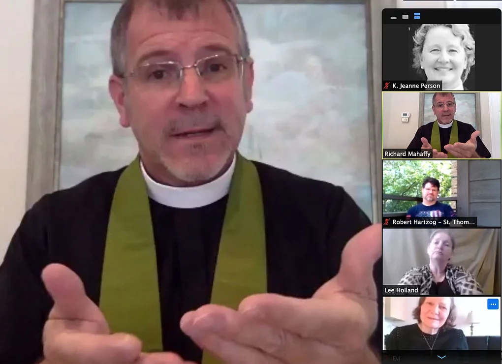 629ba6_eb920ec0fd9d4a6ab7e9fa3cbb1ad16c~mv2 A pastor in a black robe and green stole, with his hands visible for sign language, speaks during a video call, with five participants visible on the side.
